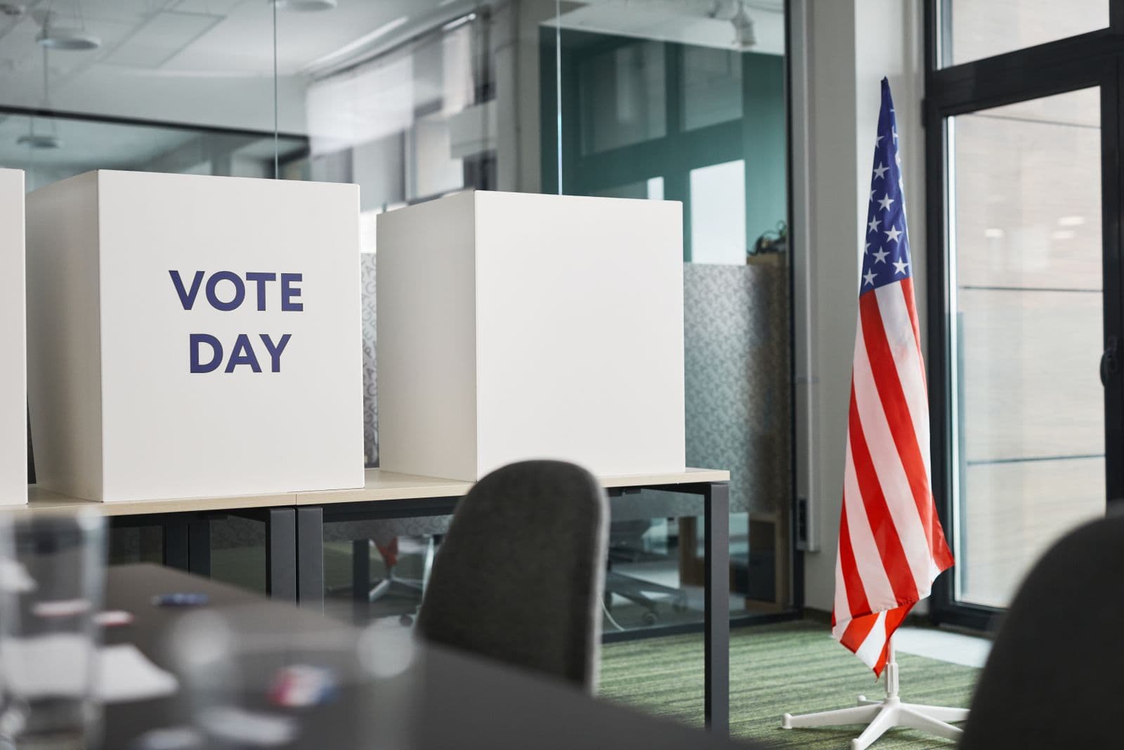 Voting booths with an American flag in an office setting, symbolizing election technology